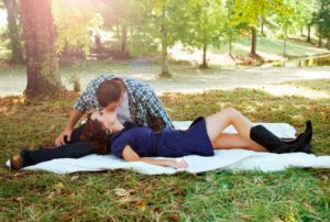 Couple kissing on a sunny day in the park