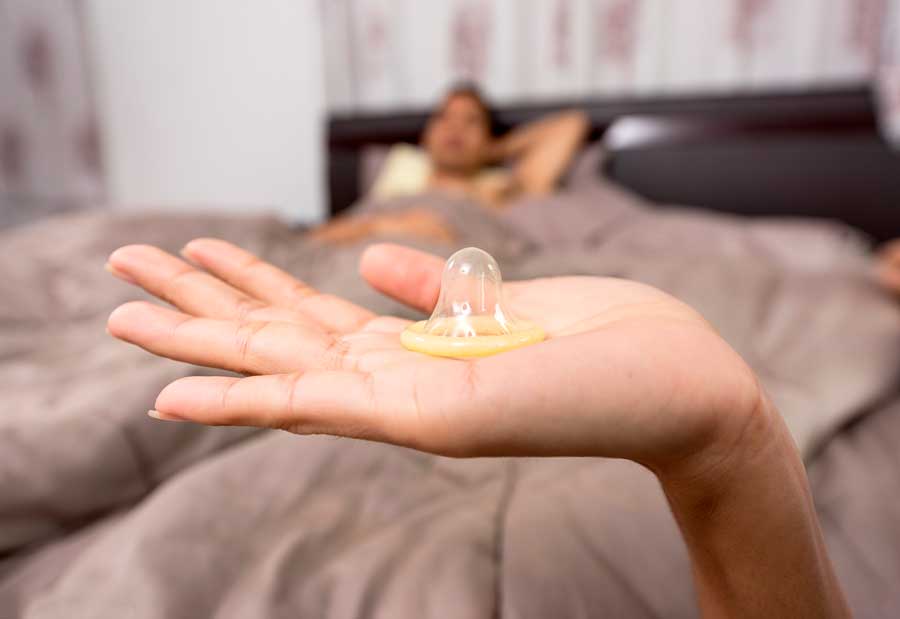 mano mostrando preservativo